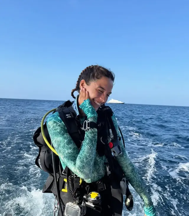 Clara sonriendo en un barco con su equipo de buceo