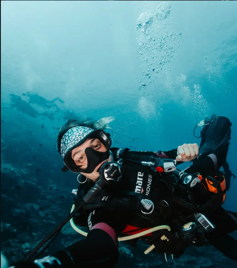 Clara buceando bajo el agua junto a un dugongo